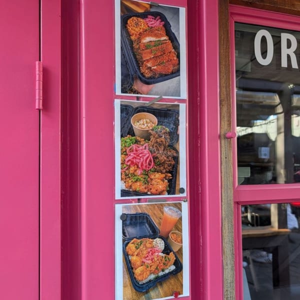 Three food photos on a bright pink wall, showcasing various dishes in takeout containers.